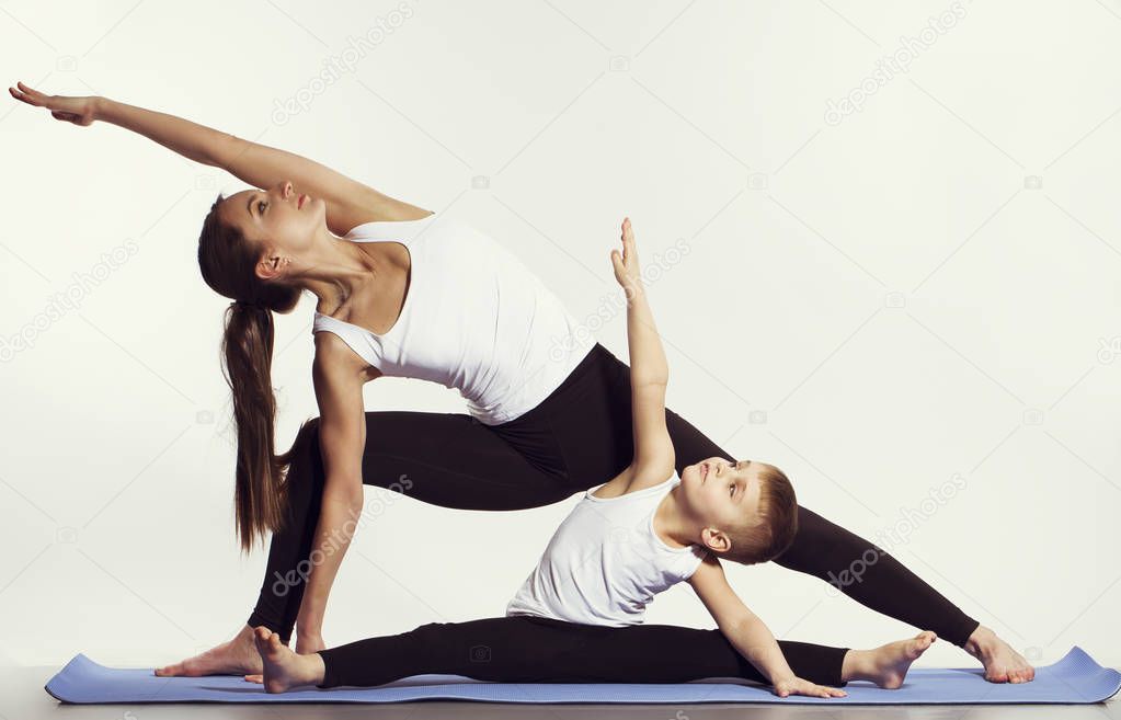 mother and son doing yoga (sports exercises), have fun and spend a good time together . isolated on white. the concept of a healthy lifestyle