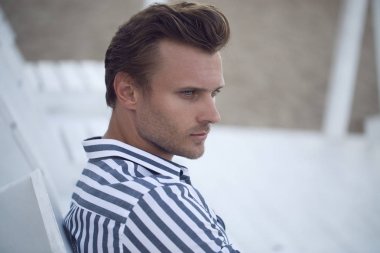 Genç yakışıklı model plaj-şezlong üzerinde poz 