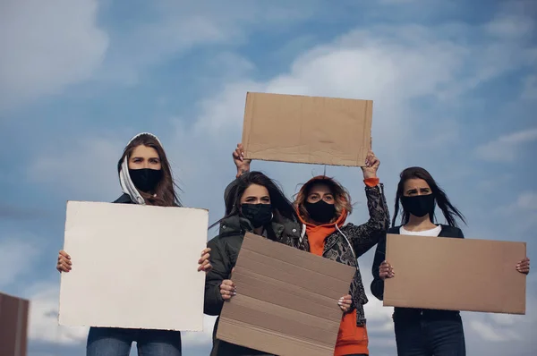 一群戴面具的妇女走在路上抗议 手里拿着一块干净的纸板作题词 — 图库照片