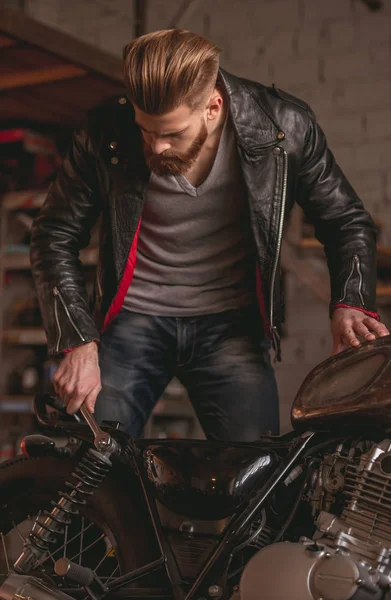 Guy dans un atelier de réparation de moto — Photo