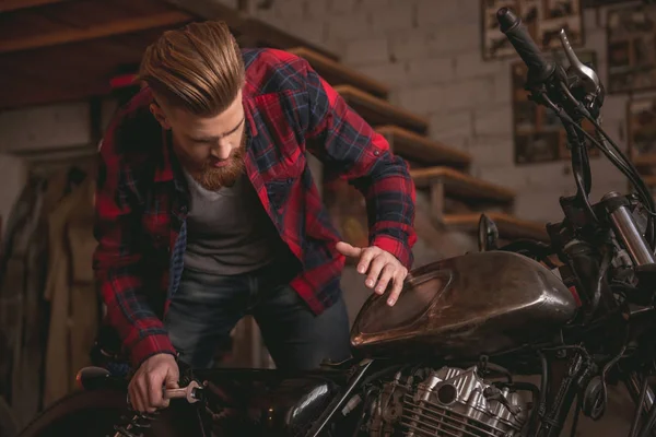 Guy dans un atelier de réparation de moto — Photo