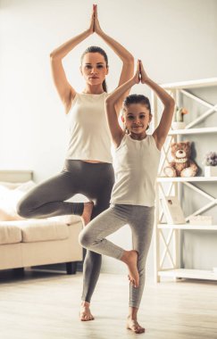 Anne ve kızı yoga yaparken