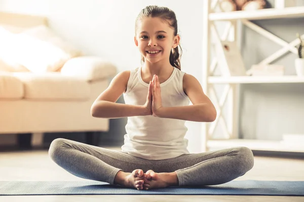 Yoga yaparken küçük bir kız — Stok fotoğraf