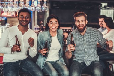 TV izlerken çubuk. Bira içip otururken el hareketi mutlu genç arkadaşlar bar.