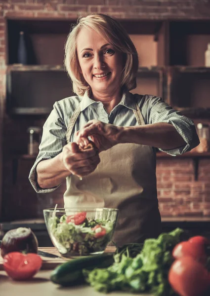Зрелая женщина на кухне — стоковое фото