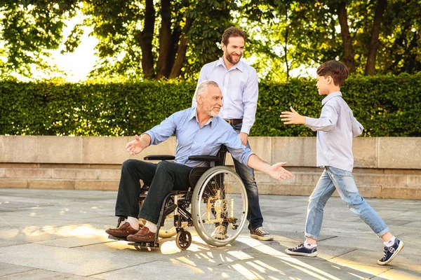 Vydařené setkání. Syn a vnuk přišel do starého muže na vozíku — Stock fotografie