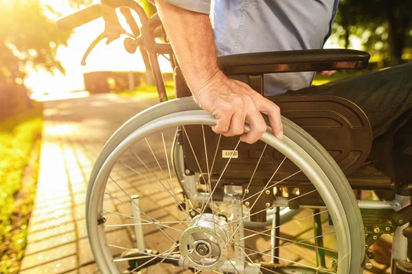 Close up. An old man is sitting on a wheelchair in the park — Stock Photo, Image