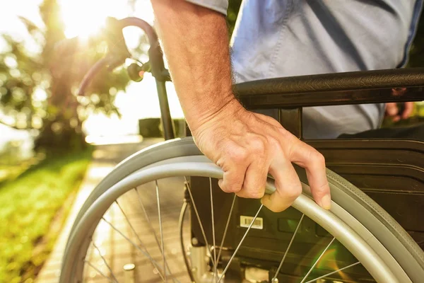 Close up. An old man is sitting on a wheelchair in the park — Stock Photo, Image