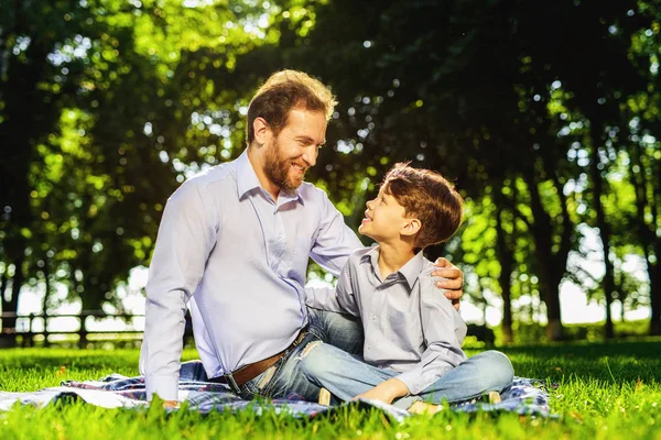 Un hombre y su hijo en un parque en un picnic. Son felices. — Foto de Stock