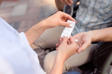 Doktor sokakta oturan bir hasta için hap verir