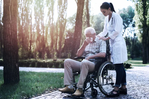 Doctor consuela al viejo llorón en el parque de verano —  Fotos de Stock