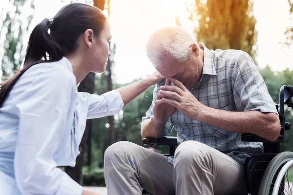 Läkaren lade sin hand på axeln av ruvande gubben — Stockfoto