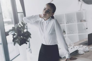 Onun işyerinde ofiste oturan hasta kadın. O bir boynu vardır ve o onu için tutar