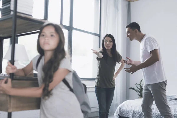 The mother angrily points her father's hand at their daughter, who stands in front of them with a backpack — Stock Photo, Image