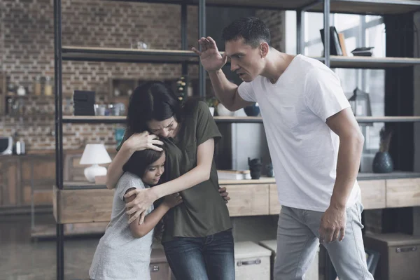 The mother protects the daughter from the evil father, who wants to hit the girl — Stock Photo, Image