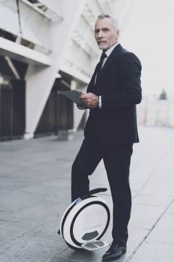 İşadamı bir monowheel üzerinde bir tablete arıyor.