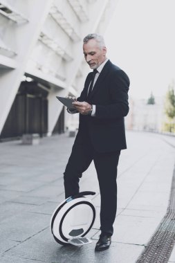 İşadamı bir monowheel üzerinde bir tablete arıyor.