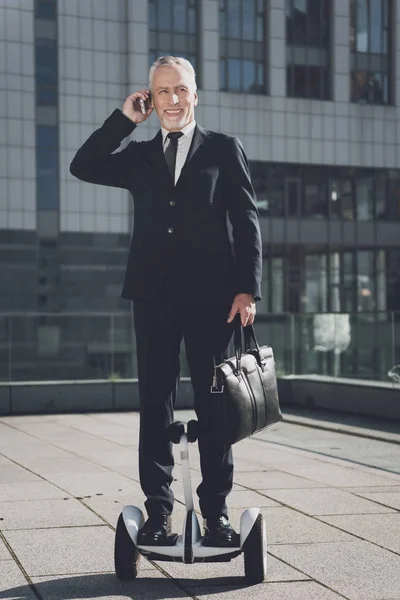Mono-tekerlek üzerinde işadamı telefonda konuşuyor.
