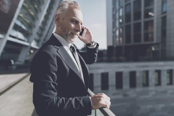 Hombre con traje negro hablando por teléfono . — Foto de Stock