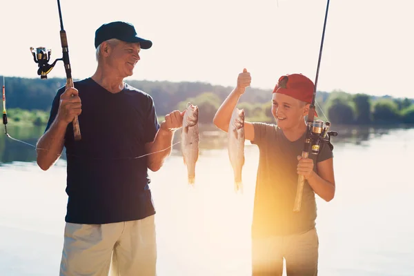 Der alte Mann und der junge Mann fingen zwei große Fische auf ihren Spinnweben — Stockfoto