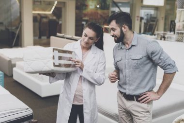 Ortopedik bir kadın adam satın almak istediği yatak örneği gösterir.