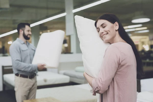 Een paar in een grote winkel van bedden en matrassen kiest kussens. Ze onderzoeken verschillende varianten van kussens — Stockfoto