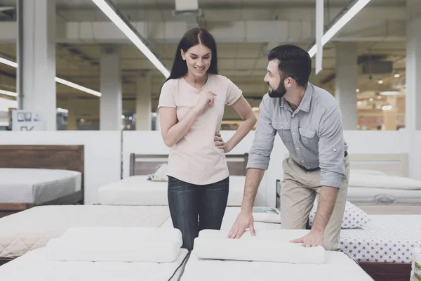 Ett par i en stor butik inspekterar madrassen innan du köper. De står bredvid honom och studerar honom — Stockfoto