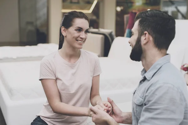 The couple chose a new bed for themselves, they are happy and are sitting on a new bed in the store — Stock Photo, Image