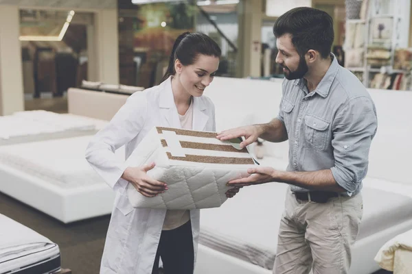 Una donna ortopedica mostra all'uomo un campione del materasso che vuole comprare — Foto Stock