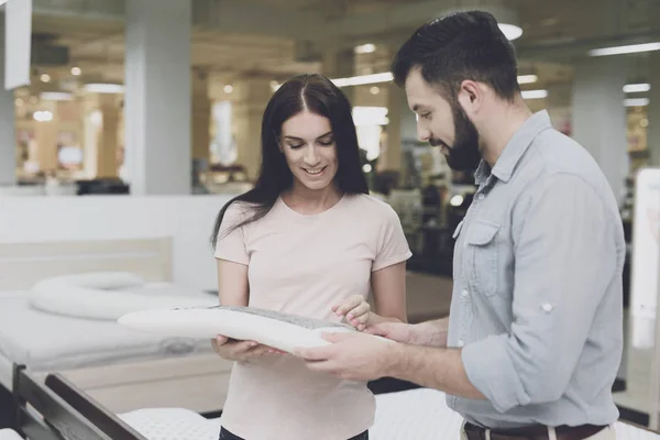 Ett par väljer en madrass i en stor butik. De tittar på ett mönster — Stockfoto