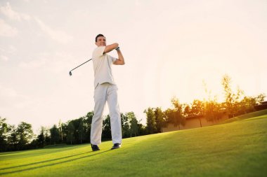 Büyük darbe. Beyaz elbiseli bir adam golf oynuyor. onun darbe ile mutluluk duyar