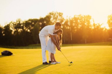 Golf oynamak bir kız öğrenir, bir adam ona saldırmadan önce onu sopa yönlendirerek yardımcı olur