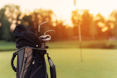 Yakın çekim. Gün batımı arka plan üzerinde golf kulüpleri ile golf kulüpleri için bir çanta
