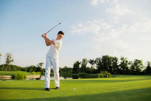 An athlete in a white suit took a golf club to strike — Stock Photo, Image