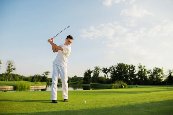 Beyaz elbiseli bir atlet grev bir golf kulübü aldı