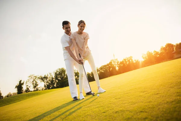 Data romântica no campo de golfe. Casal aprendendo a jogar golfe — Fotografia de Stock