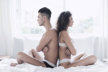 Genç bir çift yatakta oturuyor. Adam ve kız birbirlerine ve sit uzak geri döndü