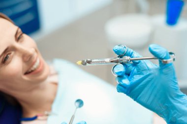 Bir kadın diş bir sandalyede oturuyor ve gülümseyerek. O dişleri ile tedavi edilebilir