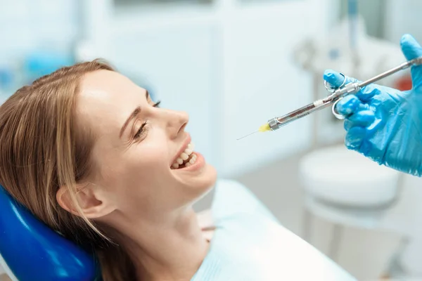 Kobieta siedzi w Fotel dentystyczny i uśmiecha się. Ona będzie być leczone zęby — Zdjęcie stockowe