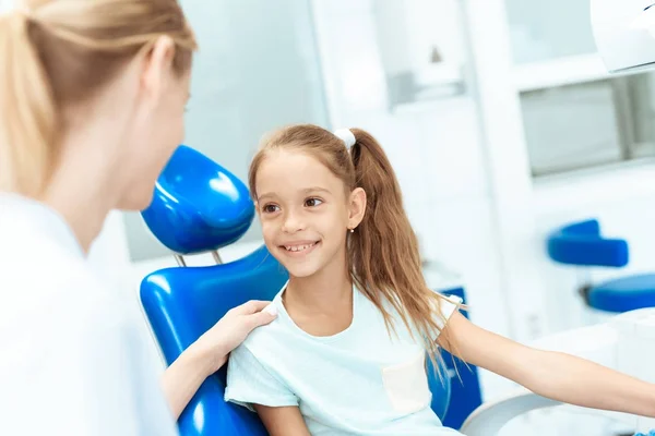 치과 의사와 리셉션에서 작은 소녀. 그녀는 치과 자에 앉아서 치과와 통신 — 스톡 사진
