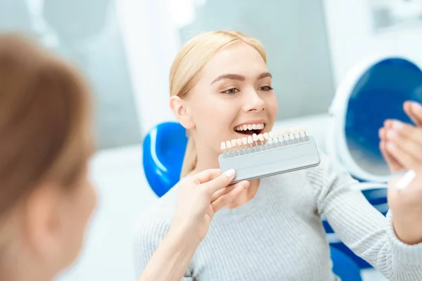 Egy nő jött, hogy a fogorvos-fogfehérítés. A fogorvos határozza meg a színét a fogát — Stock Fotó