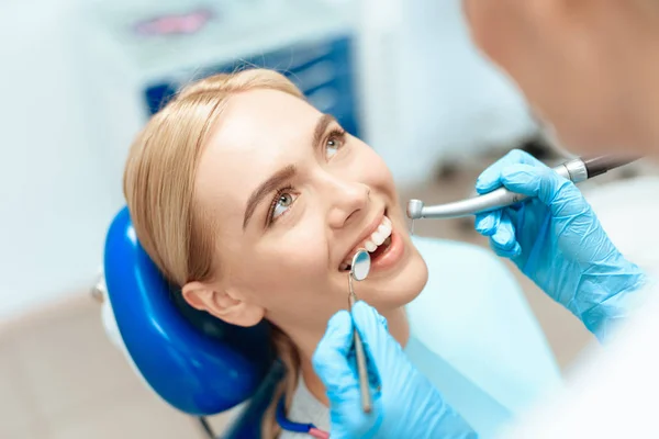 Η γυναίκα ήρθε στο οδοντιατρείο. Κάθεται σε η οδοντιατρική καρέκλα και χαμογελαστός — Φωτογραφία Αρχείου