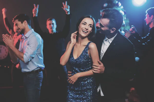 La gente se divierte en la fiesta de Año Nuevo. En primer plano, un chico y una chica están bailando . — Foto de Stock