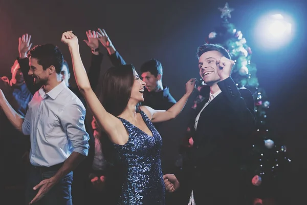 People have fun at the New Year's party. In the foreground, a guy and a girl are dancing. — Stock Photo, Image