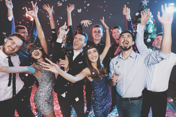 Young people have fun at a New Year's party. Around them flies confetti. They are having fun. — Stock Photo, Image