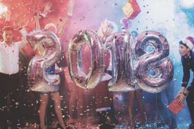 Gençlerin yeni yıl partisinde büyük parlak Ulusal teketim numaraları 2018 şeklinde ile poz olan. Çocuklar eğleniyor musun. Arkalarında çok renkli bir sis olduğunu.