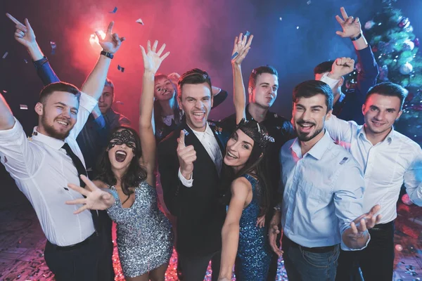 Young people have fun at a New Year's party. Around them flies confetti. — Stock Photo, Image