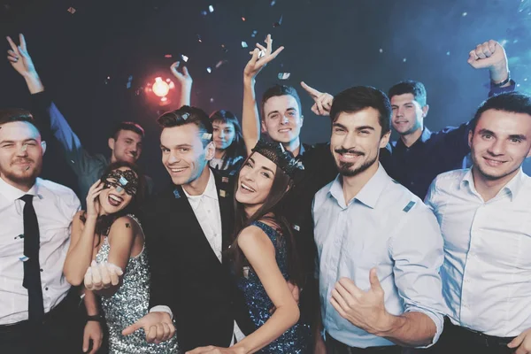 Young people have fun at a New Year\'s party. Around them flies confetti.