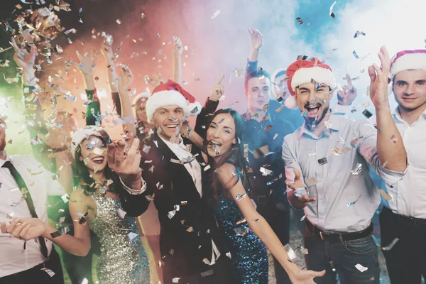 Young people have fun at a New Year's party. Around them flies confetti. — Stock Photo, Image