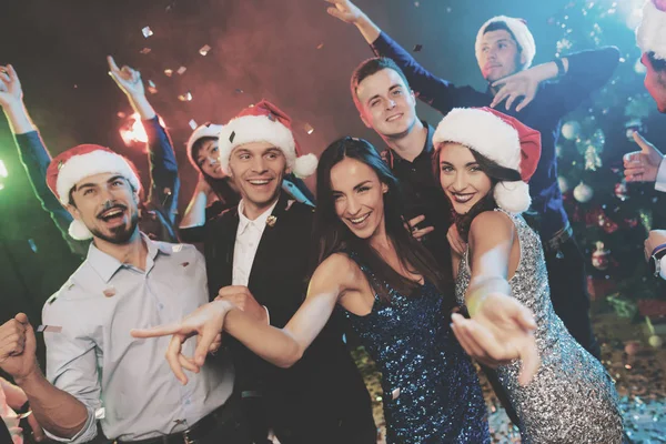 Jugendliche haben Spaß bei einer Silvesterparty. Um sie herum fliegt Konfetti. — Stockfoto